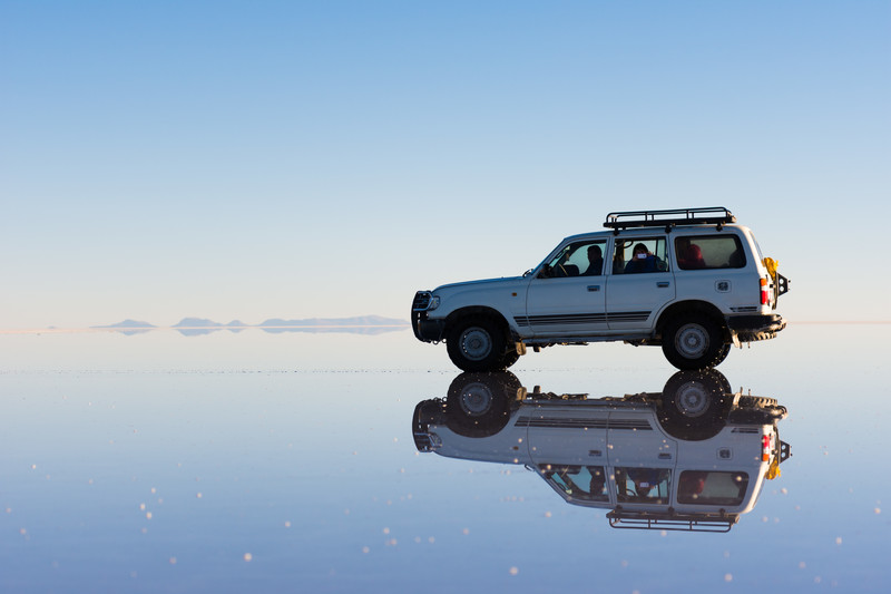 ウユニ塩湖の水面に車が映っている様子